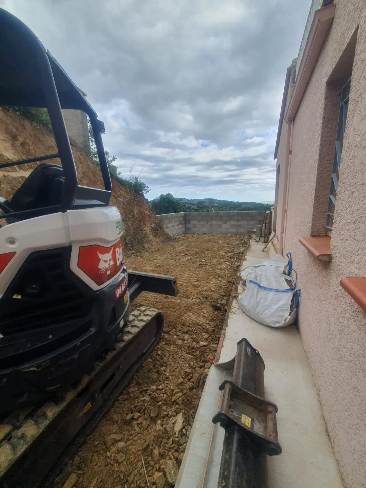 Mini-pelle dans la tranchée le long de la maison - Pyrénées-Orientales